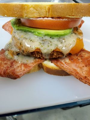 Vegan chicken bacon sandwich. Served on a vegan brioche bread, in-house sandwich spread topped with vegan cheddar cheese, in-house ranch, avocado, vegan bacon, and tomatoe at Julie's Guilt-Free Sweet Treats in Tucson