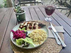 Aubergine topped with lentils, tomato and tahini. Side of salad and bulgur wheat    at Kumin Vegan Lezzetler in Istanbul