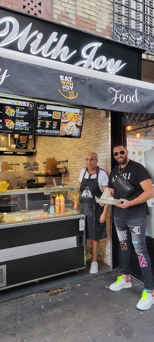 Le gérant avec un client at Eat With Joy in Paris