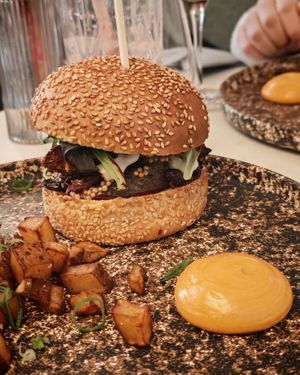 ASIAN STYLE BURGER
Crispy seitan with ginger and garlic, salad, melted cheese, caramelized onions, roasted portobello mushrooms, mustard seed pickles, smoked beet ketchup,
 at brEAThe Restaurant | Sushi végétal à Paris in Paris