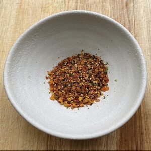 Zero waste homemade togarashi, a vibrant Japanese spice mixture combining dried fermented tomatoes, orange peel, sesame seeds, chili flakes. 🍅 🌶  at Table 13 in Wheatley