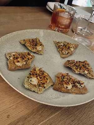 Welcome snack: falafel crackers, whipped humus, confit lemon jam, fermented tomato skin togarashi. Paired with slightly bitter but fruity tomato Negroni 🍅  at Table 13 in Wheatley
