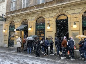 Snowy day- entrance with line waiting for opening   at Figlmüller in Vienna