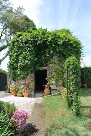 Next to the pool, this beautiful old mill standing on the garden. at Colina Flora in Colares