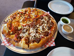 Half Ru's Veggiesaurus and half Vegan Ranch Supreme, served with pesto and alfredo dipping sauces. One of the best pizzas I've ever had. Photo taken April 2019. at Rudy's Pizza in Portland