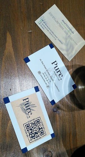 Business cards of the place, with a QR code to the menu (that I could not figure out on my phone ^^)  at Pure. Healthy Cafe in Casablanca
