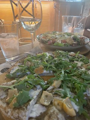 Vegan and gluten free pizza. In the back there’s a salad with heura  at Bresca in Madrid