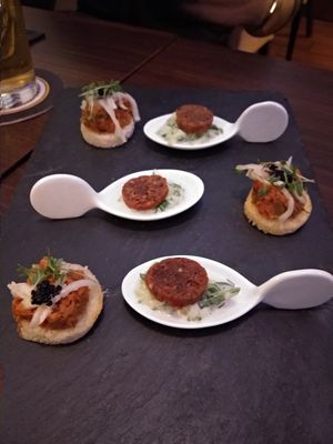 Appetizer of vegan caviar and eggplant toastie and a bean sausage on a herbed yogurt. at Lucky Leek in Berlin