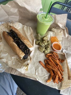 Mushroom cheesesteak, cauliflower nuggets, dill sweet potato fries and a Green Mile drink   at Green Seed Vegan in Houston