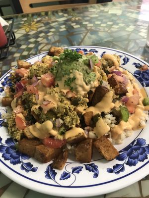 Brunch with rice, beans, guac, tofu scrambles, veggies, greens and garlic avioli. Very good! at Sweet Pea Cafe in Tallahassee