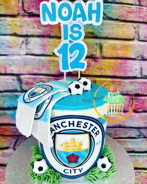 Cute little Man City cake! Cookies & cream cake with buttercream stripes, fondant scarf, footballs and edible image badge at The Nakey Cakey Bakery in Castletown
