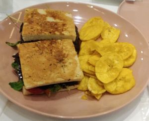 Vegan Reuben Sandwich with fried plantain: Vegan Pastrami, arugula, pickled onion, bell pepper dressing in focaccia bread

 at Kitchen in Panama City