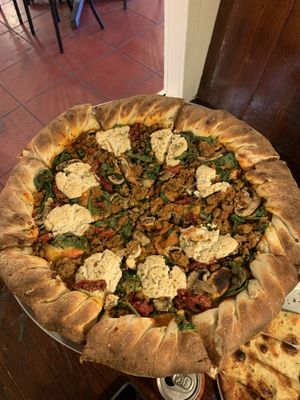 Build your own large pizza with stuffed crust, cashew ricotta, spinach, mushrooms, roasted tomatoes, and pink sauce  at Pi Vegan Pizzeria in Seattle