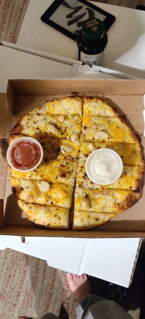 Cheesy garlic bread with garlic and marinara sauces at Pi Vegan Pizzeria in Seattle