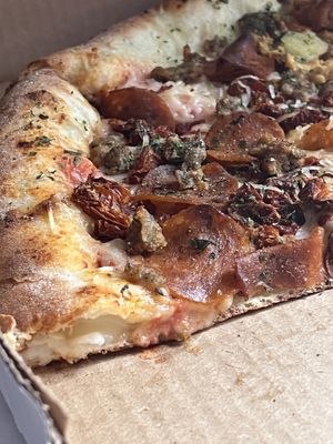 Their vegan stuffed crust pizza with pepperoni, sausage, and sun dried tomatoes   at Pi Vegan Pizzeria in Seattle