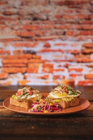 Huevo con Aguacate - Huevo de rancho estrellado sobre una rebanada de pan de caja orgánico, con base de aguacate untado, coronado con jitomate, espinaca, cilantro y pepita.  at Molletería Central in Valle De Bravo