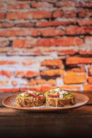 Crema de Cacahuate - Crema de cacahuate orgánica y mermelada de fresa artesanal untados sobre una rebanada de pan de caja orgánico con un topping de kiwi, fresa y almendra.  at Molletería Central in Valle De Bravo