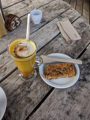 Turmeric oatmilk latte and vegan apricot pumpkin seed flapjack at Pillars of Hercules Organic Farm Shop and Cafe in Falkland