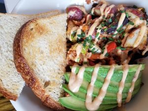 Cheesy Hash - chorizo, roasted veggies, melted Violife chz, house potatoes, sliced avocado, drizzled with chipotle sauce. Served with toast. at The LaFayette Place in Milwaukee