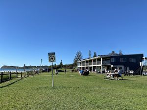 The grass with tables in front of the kiosk at Kiosk Lennox Beach in Lennox Head