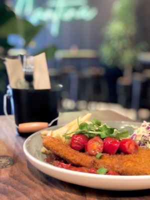 Plant-based schnitzel with various toppings and sides. at La Cantina in Tauranga