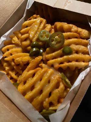 Loaded vegan fries, with vegan melted cheese and jalapeños at Leon in Cobham