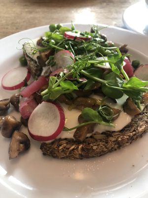 wonderbread (vegan, glutenfree; seeds) toast w peas, champignons, pickled onions, radish  at Café des Amis in Zurich