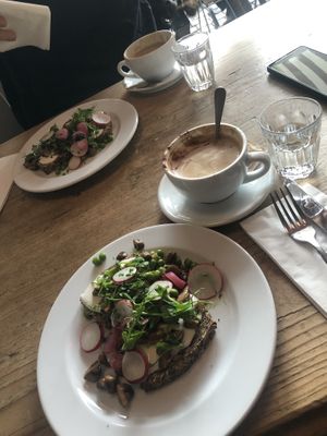 big cappucinos w a glass of water included  at Café des Amis in Zurich