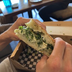 Pesto Chxn & Cheddar Panini, on focaccia bread  at Imposter Cafe and Provisions  in Vancouver