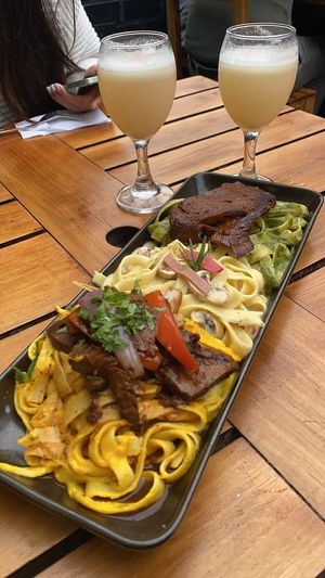 Trio de pastas! 1) spaghetti with huancaina sauce + lomo saltado, 2) Alfredo spaghetti, 3) pesto pasta with seitan steak! + delicious vegan pisco sours!  at Gastronomía Vegana in Lima
