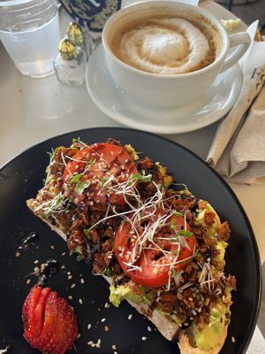 VLT avocado toast with coconut bacon 😋 and oat milk cappuccino. The vibe was mellow and inclusive. My new favorite coffee house!  at FeelLove Coffee in Loveland