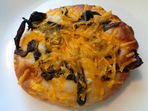 Bialy topped with roasted poblano pepper and plant cheddar. at Evexia in Aurora