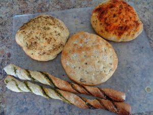 3 Mini Focaccias in Tuscan Seasoning, Sea Salt, and Fresh Herbs and Aleppo Pepper and 2 Pesto Breadsticks. Great sizes for slicing and sharing. Available g/f. at Evexia in Aurora
