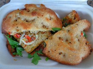 Tofu Focaccia Sandwich special. Seared tofu with plant mozzarella, red pepper pesto, peppadew peppers, aioli, arugula on a mini focaccia. Available g/f. at Evexia in Aurora