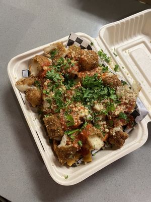 The Bomb fries on bottom and mozzarella bites with marinara drizzled throughout, Parmesan and parsley garnish at Secret Vegan Pizza in Los Angeles