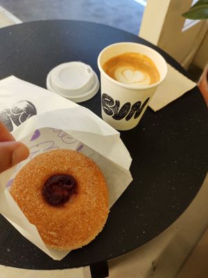 Flat white with grape jam and custard doughnut at Bun and Coffee in Malaga