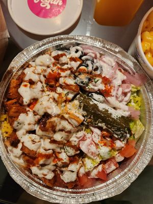 Grape leaf, jerk 🐔 on top of rice and salad w/ white sauce and hot sauce. 🔥 at Vegan On The Fly in New York City