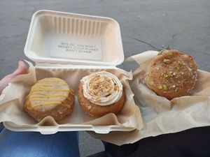 De izquierda a derecha: donut de mermelada de mango y frutos de la pasión, bomba de chocolate y avellanas y donut de pistacho at Areca Bakery in Barcelona