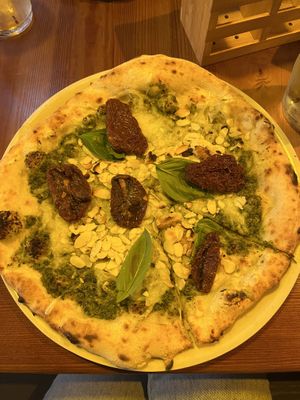 Pizza with pesto, dried tomatoes, pine nuts and almonds.  at Bella Compagnia - Meidlinger Hauptstr. in Vienna