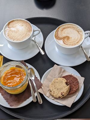 Two cappuccinos, mango cheesecake pot, cookie dough biscuit and another biscuit at Cortese Café 900 in Florence