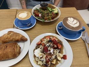 Pain au chocolat, croissant, pancakes with fruit and chocolate sauce, pancakes with tofu scramble, hot chocolate milk and cappuccino.   at Cloud Cakes -  Notre Dame de Lorette in Paris