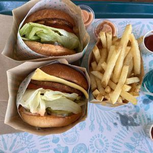 Two single-patty burgers w/ grilled onions, one w/ vegan cheese  at Amy's Drive Thru in Roseville