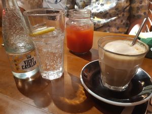 Fizzy water, juice of the day, and a cappuccino with veg milk at Zenith Brunch & Cocktails in Madrid