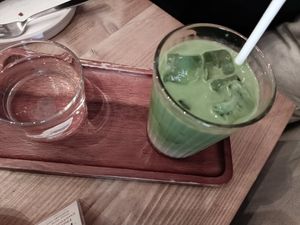 Iced matcha latte with glass of water at Gecko Coffeehouse in East London