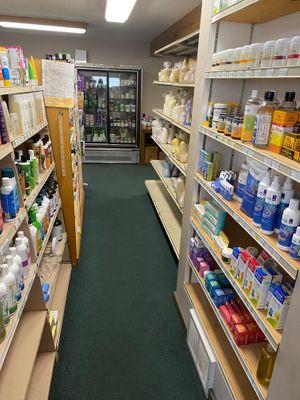 Aisle of supplements with a fridge case at the end at Pure N Simple in Glens Falls