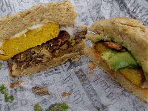 Egg, Bacon, Avocado, and Aioli Sandwich and Sausage, Egg, and Cheese Biscuit cut in half at Dulce Vegan Bakery and Cafe in Atlanta