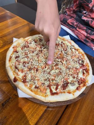 Mit Finger für den Größenvergleich. Pizza ohne v- Wurst  at Plant-erian in Krabi