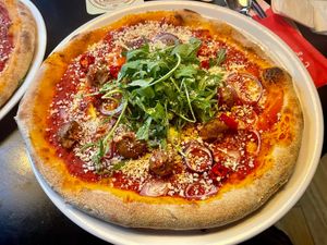Pizza Spicy 'Meatballs' - Tomatensaus, Italiaanse gehacktballetjes, rode ui, rode paprika, rode pepers, rucola, pittige saus en vegan kaas - €13.75 at Happy Italy  in Spijkenisse