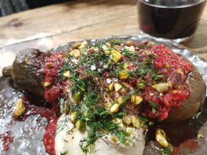 Grilled eggplant with herbs, hummus, berries and pistachio at Honest Greens - Tuset in Barcelona