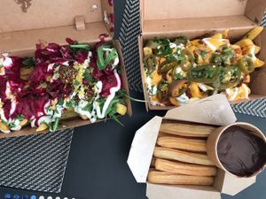 Pink Persia Poutine (left), chili cheese fries (right), and churros with chocolate sauce at Frittenwerk - Hbf Leipzig in Leipzig